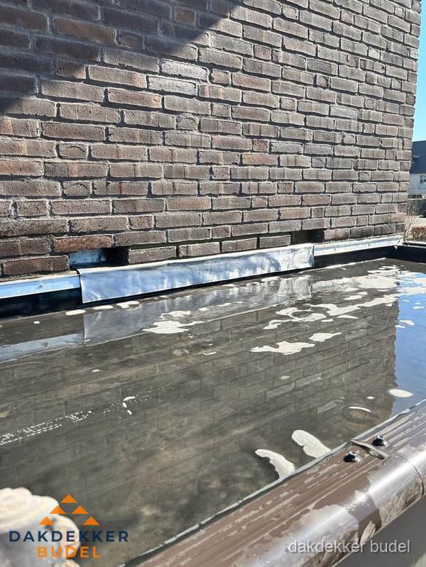 Stilstaand water op plat dak door slechte afwatering in Budel