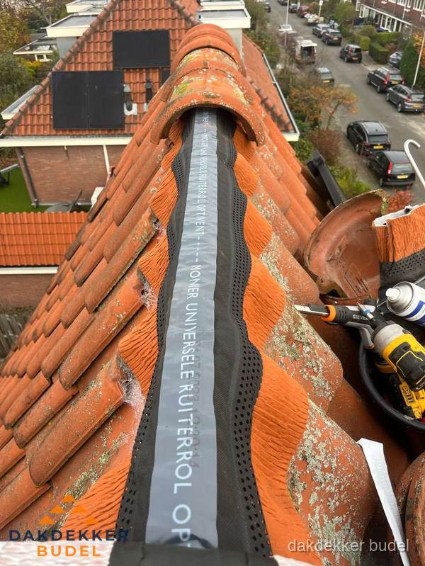 Dakdekker vervangt nokvorst met ruiterrol op pannendak in Budel