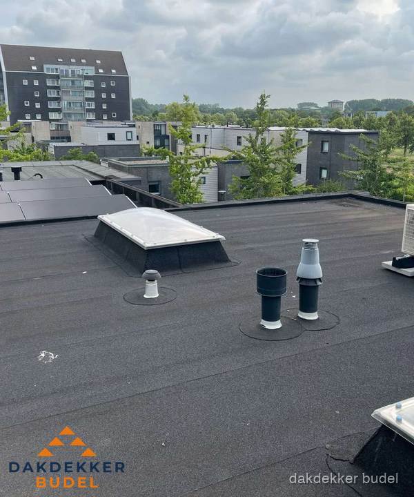 Groot plat dak met lichtkoepel en dakdoorvoeren in Budel Groot plat dak met lichtkoepel en dakdoorvoeren in Budel