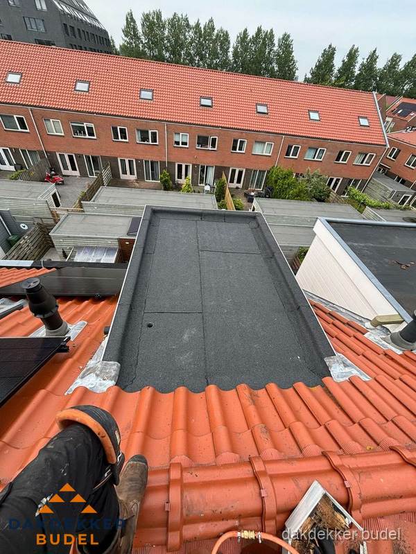 Bitumen dak reparatie op plat dak tussen dakpannen in Budel
