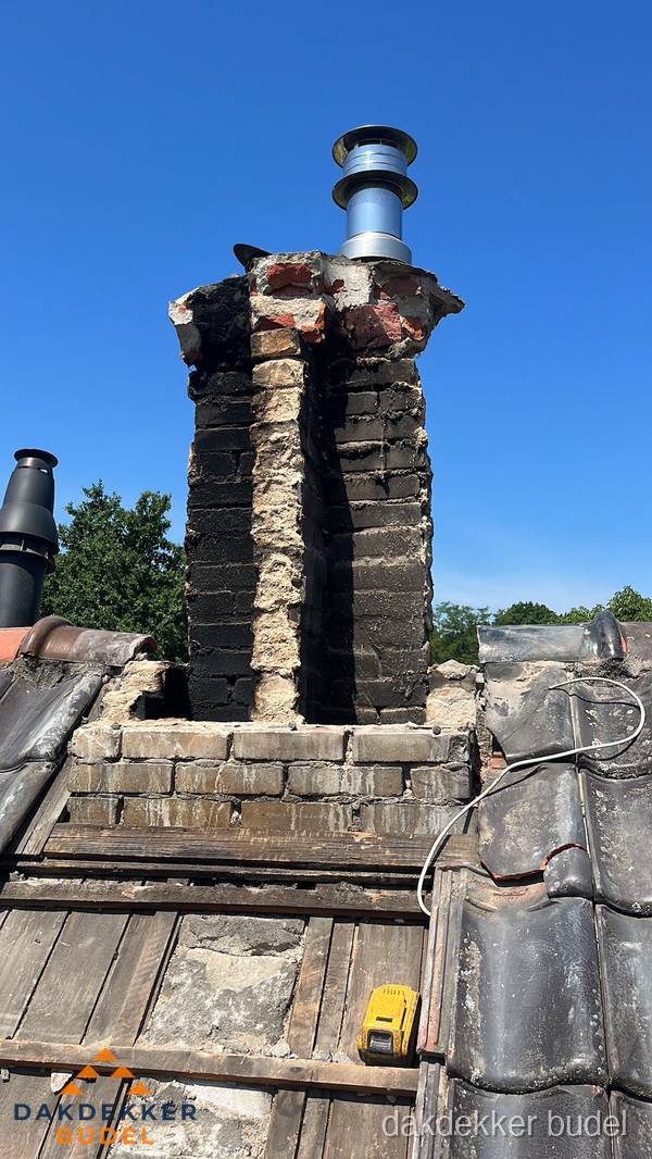 Beschadigde schoorsteen met nieuwe rookgasafvoer op oud dak in Budel