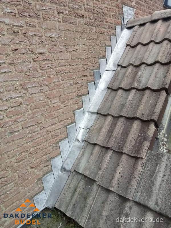 Loodslabben langs dakaansluiting bij bakstenen muur in Budel